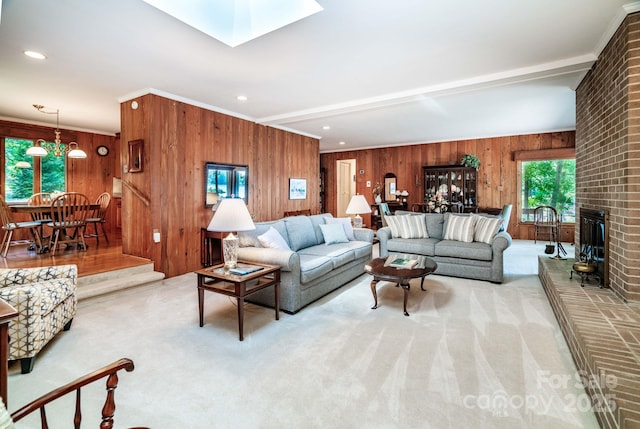 8448 Normandy Rd, Denver, NC 28037 - carpeted living room with wooden walls, a skylight, ornamental molding, and a fireplace