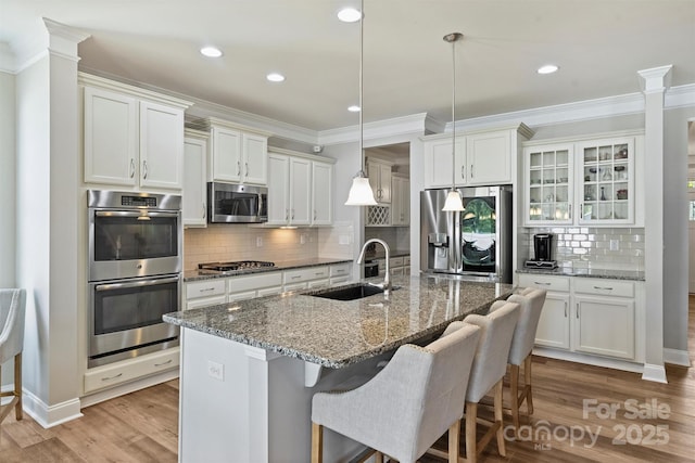 10906 Angler Ct, Davidson, NC 28036 - kitchen with stainless steel appliances, ornamental molding, light wood-style flooring, a kitchen bar, and decorative backsplash