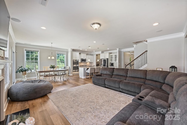 10906 Angler Ct, Davidson, NC 28036 - living area featuring ornamental molding, light wood finished floors, stairs, and recessed lighting