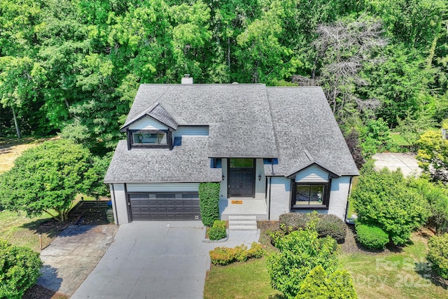 9334 Hunting Ct, Matthews, NC 28105 - view of front facade featuring an attached garage, roof with shingles, a chimney, and concrete driveway