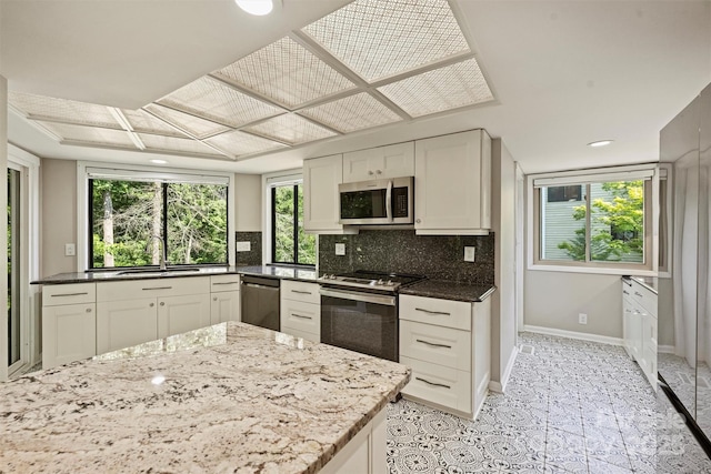 9334 Hunting Ct, Matthews, NC 28105 - kitchen featuring appliances with stainless steel finishes, backsplash, dark stone countertops, light tile patterned flooring, and recessed lighting