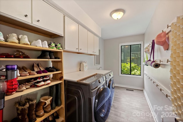 9334 Hunting Ct, Matthews, NC 28105 - washroom with washer and clothes dryer, light wood-style floors, and cabinet space