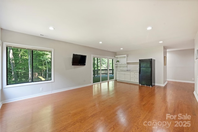 9334 Hunting Ct, Matthews, NC 28105 - unfurnished living room featuring light wood finished floors and recessed lighting