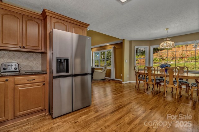 59 Old Lakey Gap Rd, Black Mountain, NC 28711 - kitchen featuring stainless steel refrigerator with ice dispenser, a textured ceiling, light wood-style floors, a chandelier, and backsplash
