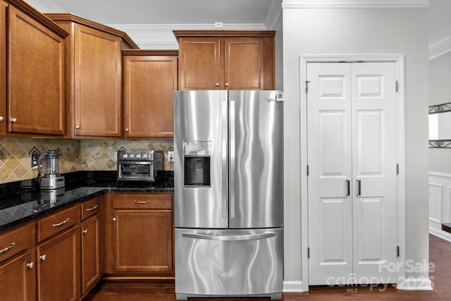 10621 Shanon Darby Ln, Charlotte, NC 28214 - kitchen featuring stainless steel fridge with ice dispenser, ornamental molding, dark stone countertops, brown cabinets, and dark wood-type flooring