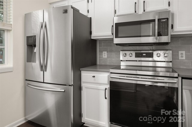 6013 Heath Valley Rd, Charlotte, NC 28210 - kitchen with appliances with stainless steel finishes, backsplash, and white cabinetry