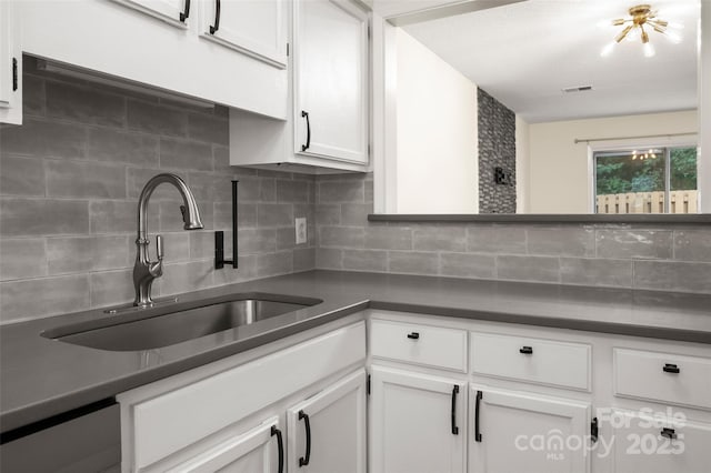 6013 Heath Valley Rd, Charlotte, NC 28210 - kitchen with backsplash, dark countertops, and white cabinetry