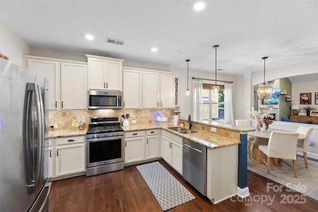 116 Kentmere Ln, Clover, SC 29710 - kitchen with stainless steel appliances, a peninsula, decorative backsplash, dark wood-style floors, and white cabinets