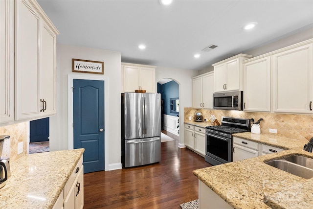 116 Kentmere Ln, Clover, SC 29710 - kitchen featuring appliances with stainless steel finishes, arched walkways, light stone counters, tasteful backsplash, and recessed lighting