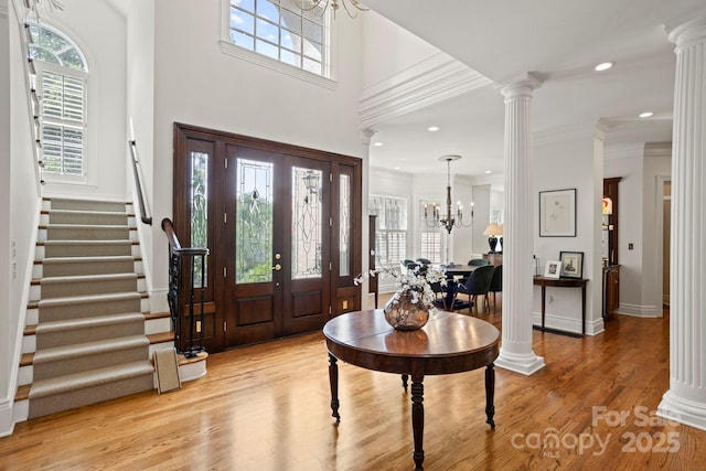 117 Founders Dr, Flat Rock, NC 28731 - entryway with light wood finished floors, stairs, decorative columns, a chandelier, and ornamental molding