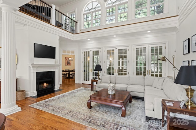 117 Founders Dr, Flat Rock, NC 28731 - living area with a high ceiling, wood finished floors, ornate columns, a fireplace with flush hearth, and french doors