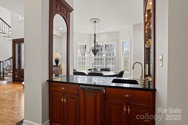 117 Founders Dr, Flat Rock, NC 28731 - bar featuring stairway, a chandelier, crown molding, light wood finished floors, and hanging light fixtures