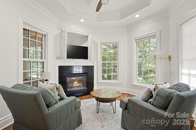 117 Founders Dr, Flat Rock, NC 28731 - living room featuring a glass covered fireplace, wood finished floors, a tray ceiling, ceiling fan, and crown molding