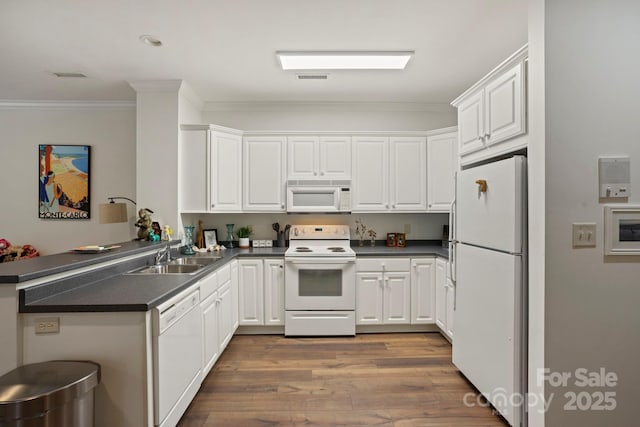 117 Founders Dr, Flat Rock, NC 28731 - kitchen with white appliances, dark countertops, crown molding, wood finished floors, and white cabinets