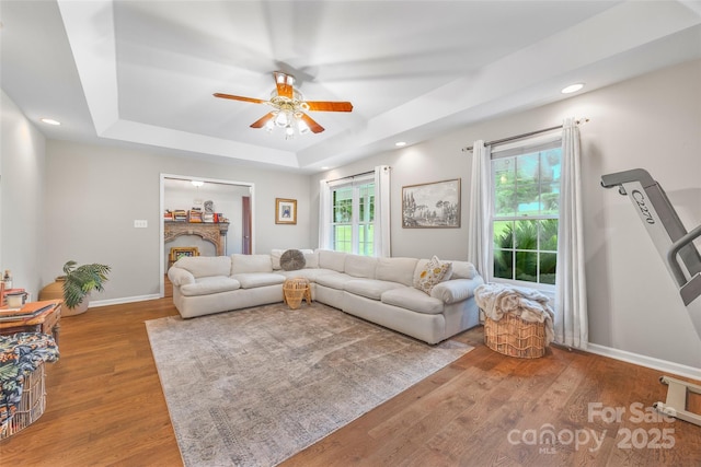 1010 Rainbow Cir, Catawba, SC 29704 - living area featuring a ceiling fan, a tray ceiling, wood finished floors, recessed lighting, and a fireplace