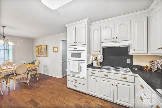 1010 Rainbow Cir, Catawba, SC 29704 - kitchen with under cabinet range hood, white appliances, dark countertops, white cabinets, and dark wood-style floors