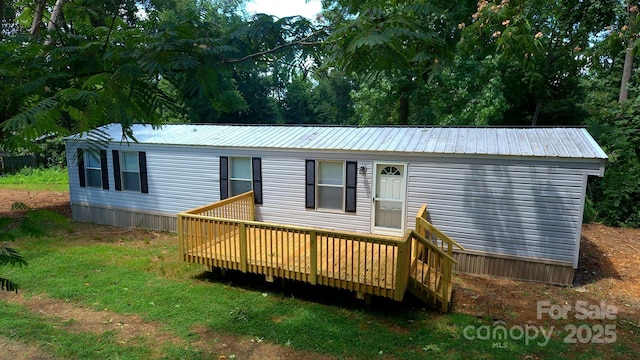 back of property with a wooden deck and a metal roof