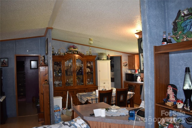 236 Hidden Cove Rd, Marion, NC 28752 - dining area featuring vaulted ceiling, a textured ceiling, and crown molding
