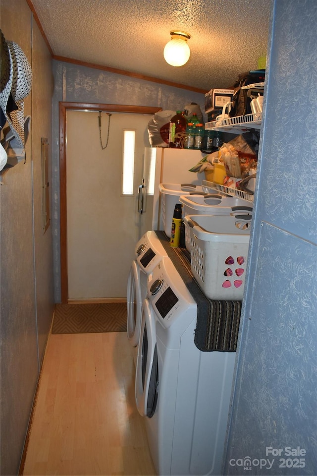 236 Hidden Cove Rd, Marion, NC 28752 - laundry room with separate washer and dryer, wood finished floors, a textured ceiling, and wallpapered walls
