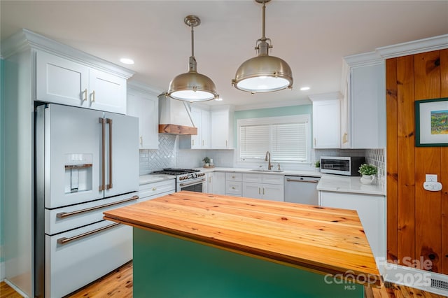 806 S Point Rd, Belmont, NC 28012 - kitchen with high quality appliances, custom exhaust hood, butcher block countertops, white cabinetry, and decorative backsplash