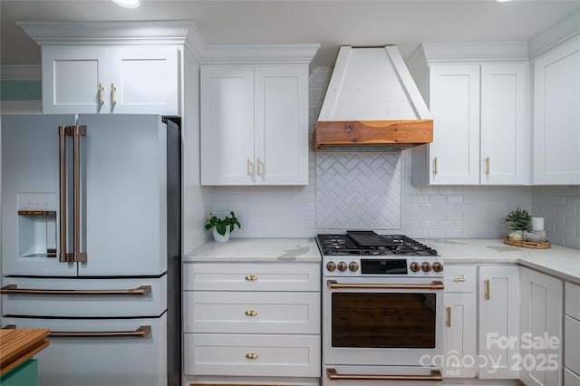 806 S Point Rd, Belmont, NC 28012 - kitchen with high quality appliances, premium range hood, white cabinetry, and decorative backsplash