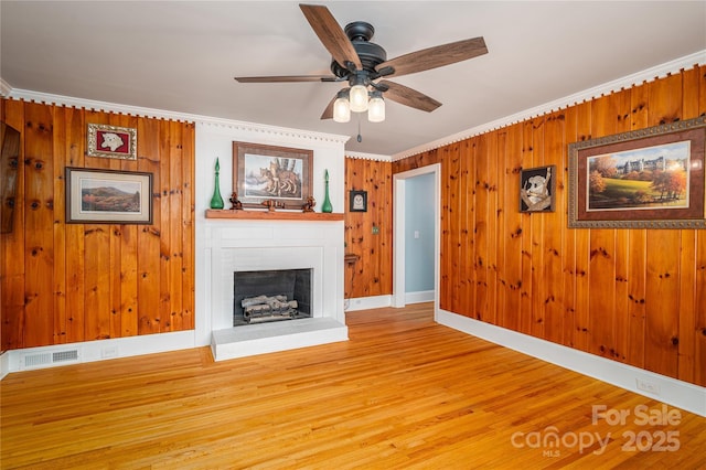 806 S Point Rd, Belmont, NC 28012 - unfurnished living room with wood finished floors, a fireplace, ceiling fan, ornamental molding, and wooden walls