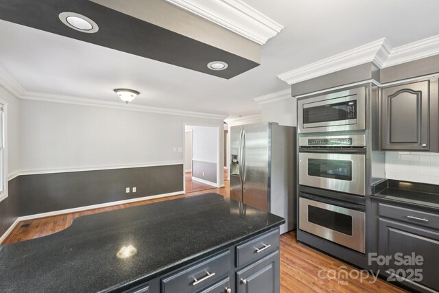 8 Hickory Ridge Ct, Clover, SC 29710 - kitchen featuring stainless steel appliances, crown molding, wood finished floors, and backsplash