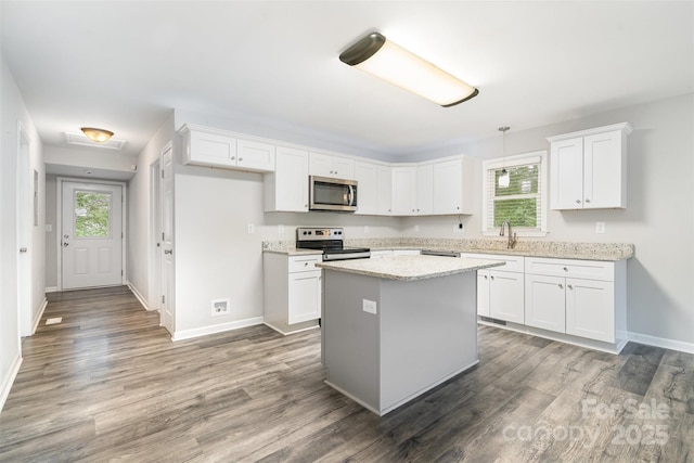8107 Smith Rd, Kannapolis, NC 28081 - kitchen with appliances with stainless steel finishes, white cabinets, and wood finished floors