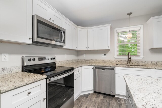8107 Smith Rd, Kannapolis, NC 28081 - kitchen featuring appliances with stainless steel finishes, white cabinets, dark wood-style flooring, and light stone countertops
