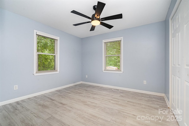 8107 Smith Rd, Kannapolis, NC 28081 - unfurnished bedroom featuring multiple windows, light wood finished floors, a closet, and a ceiling fan
