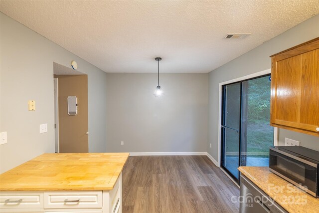 1533 20th Ave NE, Hickory, NC 28601 - kitchen with stainless steel microwave, dark wood-style flooring, wood counters, a textured ceiling, and decorative light fixtures