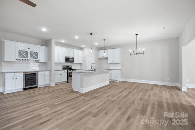 12518 Susanna Dr, Charlotte, NC 28214 - kitchen with beverage cooler, appliances with stainless steel finishes, decorative backsplash, light wood-type flooring, and recessed lighting