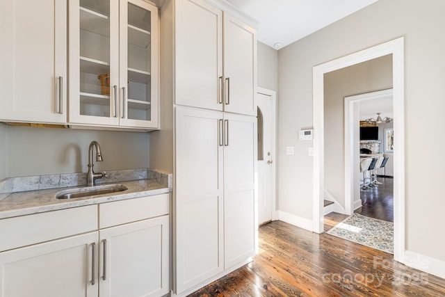 11 By The Wayside Dr, Columbus, NC 28722 - kitchen with dark wood-type flooring, glass insert cabinets, light stone countertops, and white cabinetry
