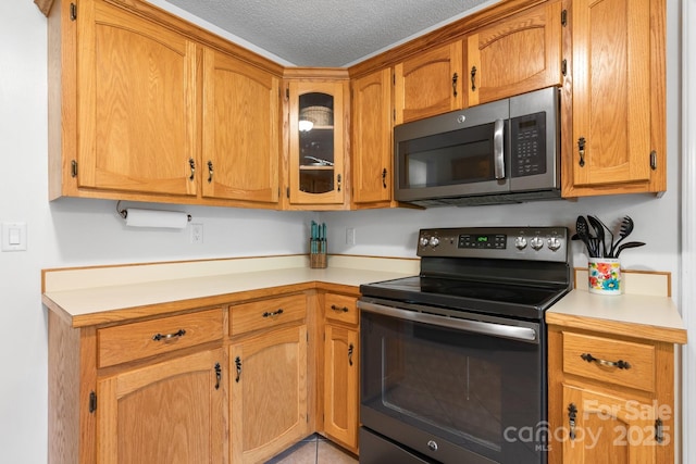 13 Fox Ridge Dr, Granite Falls, NC 28630 - kitchen featuring stainless steel appliances, light countertops, glass insert cabinets, a textured ceiling, and brown cabinets
