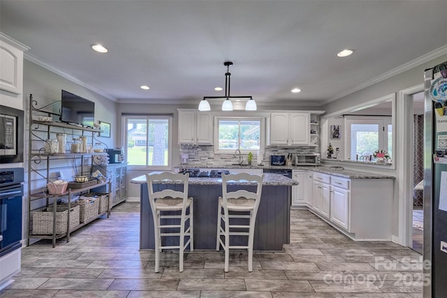 17 Heritage Dr, Lake Wylie, SC 29710 - kitchen with a center island, white cabinetry, crown molding, light stone countertops, and recessed lighting