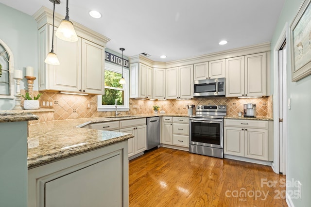 2838 Candleberry Ct, Charlotte, NC 28210 - kitchen with stainless steel appliances, light wood-type flooring, light stone counters, tasteful backsplash, and cream cabinets