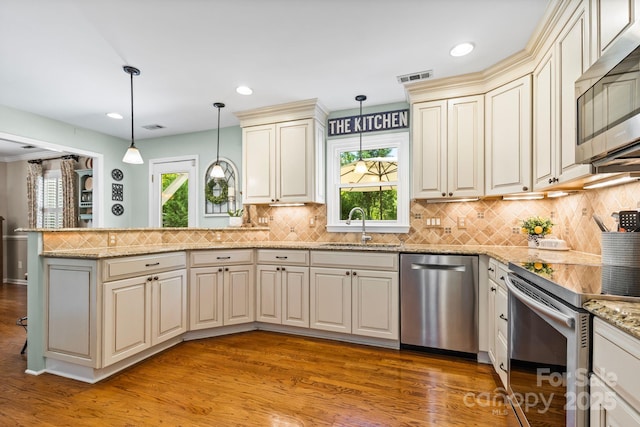 2838 Candleberry Ct, Charlotte, NC 28210 - kitchen featuring stainless steel appliances, a peninsula, cream cabinetry, light wood-type flooring, and recessed lighting