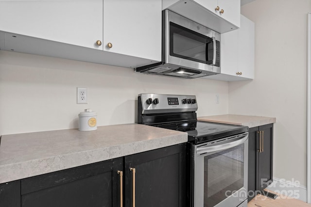 2704 Kool Park Rd NE, Hickory, NC 28601 - kitchen featuring appliances with stainless steel finishes, dark cabinets, light countertops, and white cabinetry