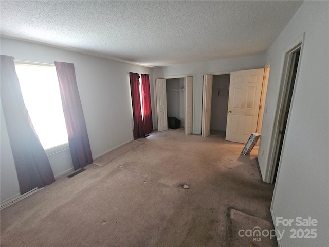 32 Sleepy Hollow Ln, Swannanoa, NC 28778 - unfurnished bedroom with two closets, carpet, and a textured ceiling