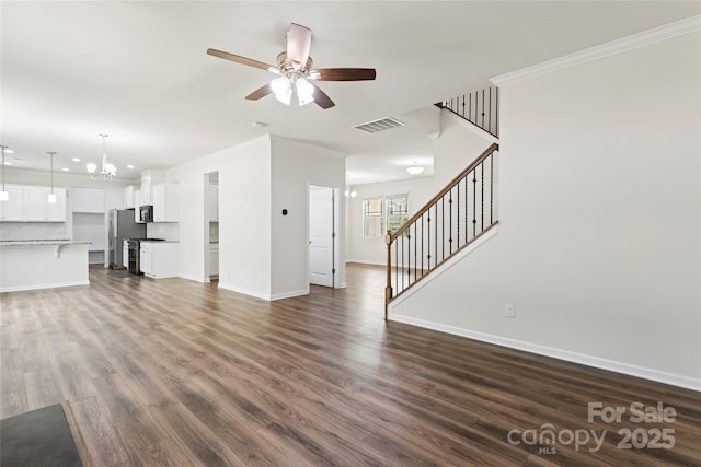 15213 Red Canoe Way, Charlotte, NC 28278 - unfurnished living room featuring a ceiling fan, stairs, a chandelier, crown molding, and dark wood-style flooring