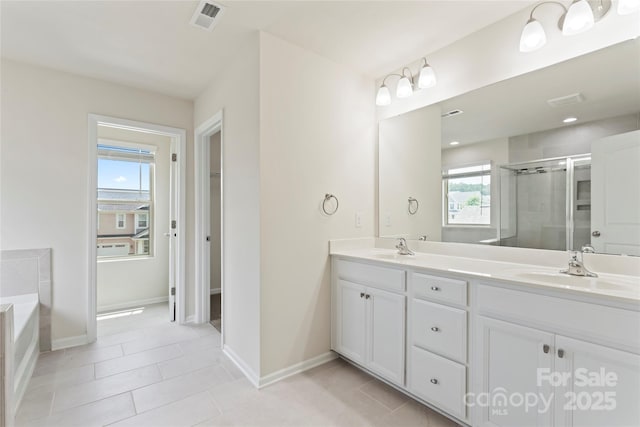 15213 Red Canoe Way, Charlotte, NC 28278 - bathroom featuring double vanity, a shower stall, a garden tub, and tile patterned flooring