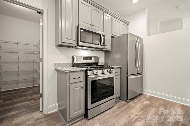321 Benjamins Way Unit 48, Hendersonville, NC 28792 - kitchen with stainless steel appliances, gray cabinets, light wood-style floors, recessed lighting, and light stone countertops