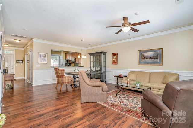 13714 Morehouse St, Huntersville, NC 28078 - living area featuring ceiling fan, dark wood-style floors, ornamental molding, and wainscoting