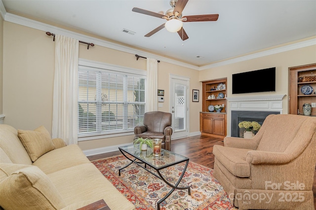 13714 Morehouse St, Huntersville, NC 28078 - living room with a ceiling fan, a fireplace, ornamental molding, dark wood-type flooring, and built in features