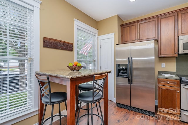 13714 Morehouse St, Huntersville, NC 28078 - kitchen featuring appliances with stainless steel finishes, dark wood-type flooring, healthy amount of natural light, and brown cabinetry