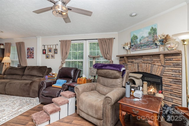 824 Brevard Place Rd, Iron Station, NC 28080 - living room featuring wood finished floors, a textured ceiling, crown molding, a ceiling fan, and a stone fireplace
