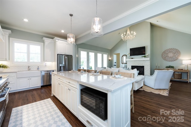 416 Yorkfield Dr, Shelby, NC 28150 - kitchen with stainless steel appliances, a stone fireplace, open floor plan, a kitchen island, and white cabinetry