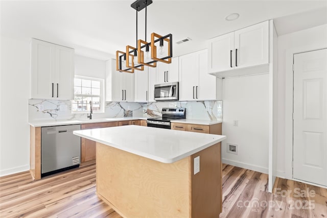 1050 Barnett Dr, Kings Mountain, NC 28086 - kitchen with appliances with stainless steel finishes, light wood finished floors, a chandelier, and backsplash