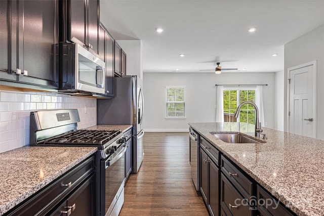 2040 Dornoch Rd, Tega Cay, SC 29708 - kitchen featuring stainless steel appliances, dark wood finished floors, light stone countertops, a ceiling fan, and tasteful backsplash