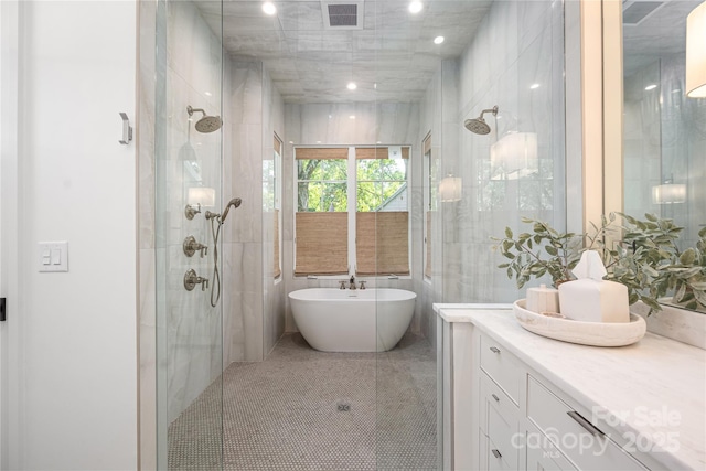 1401 Heather Ln, Charlotte, NC 28209 - bathroom featuring a shower stall, a freestanding bath, vanity, and tile walls